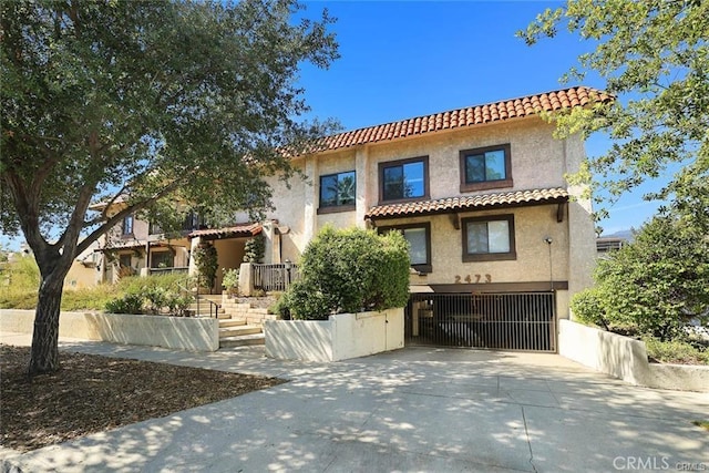 2473 Oswego St Unit 17, Pasadena, CA 91107 - mediterranean / spanish house featuring a tile roof, stucco siding, an attached garage, and driveway