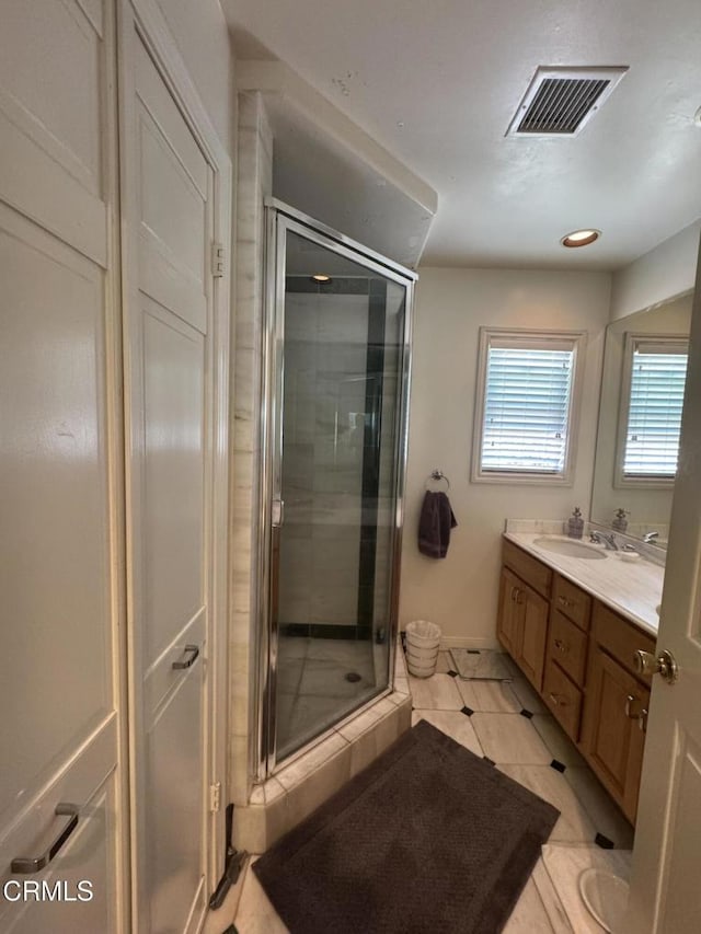 bathroom with vanity, a shower stall, tile patterned flooring, recessed lighting, and baseboards