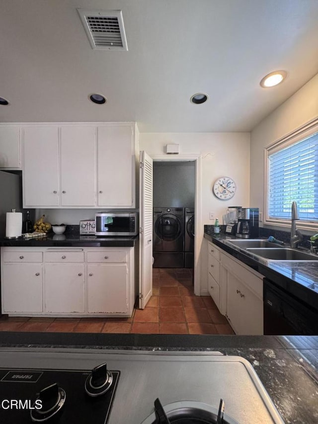 kitchen with separate washer and dryer, a sink, dishwasher, white cabinets, and dark countertops