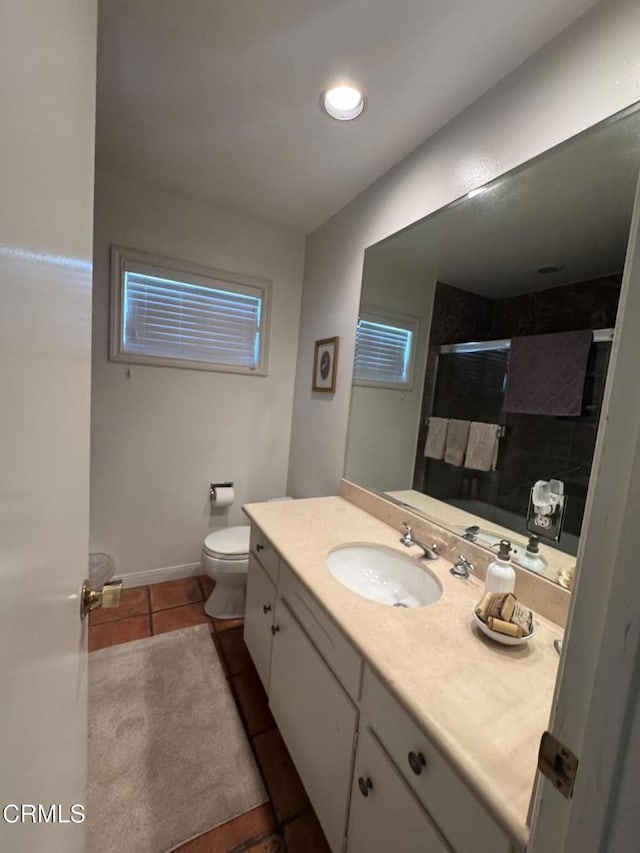 bathroom featuring tile patterned flooring, vanity, toilet, a shower, and baseboards