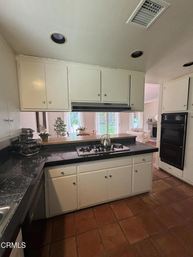 kitchen with dark countertops, black appliances, white cabinetry, and recessed lighting