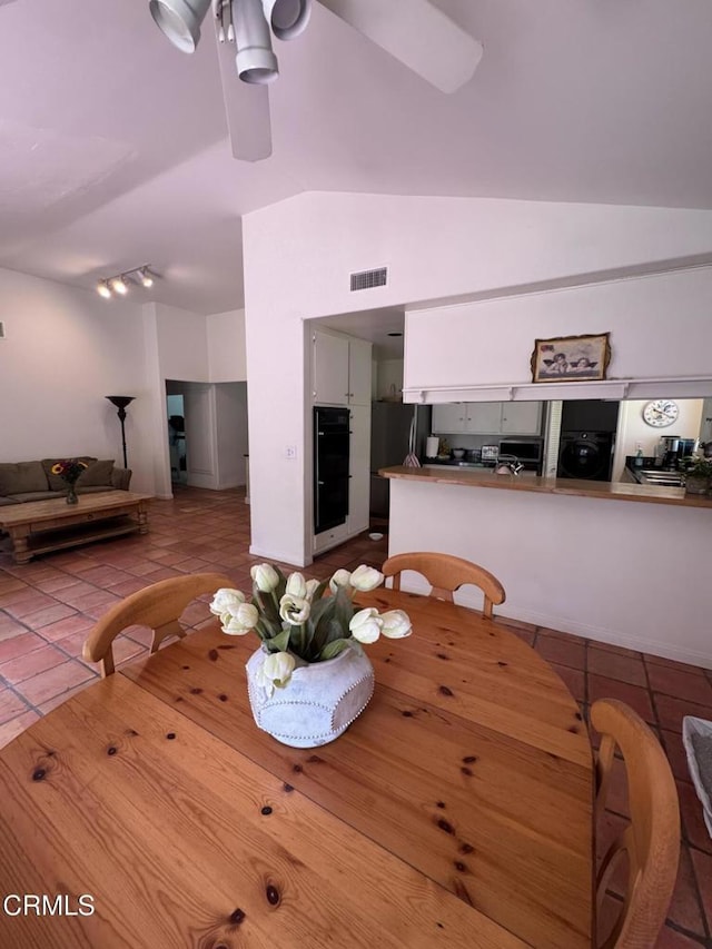 dining space with vaulted ceiling, tile patterned flooring, and washer / clothes dryer