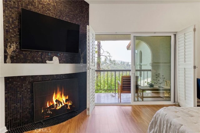 2311 Roscomare Rd Unit 16, Los Angeles, CA 90077 - bedroom with access to outside, wood finished floors, and a warm lit fireplace