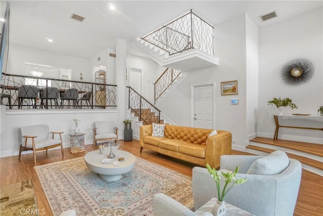 2311 Roscomare Rd Unit 16, Los Angeles, CA 90077 - living area with wood finished floors, a towering ceiling, stairs, and recessed lighting