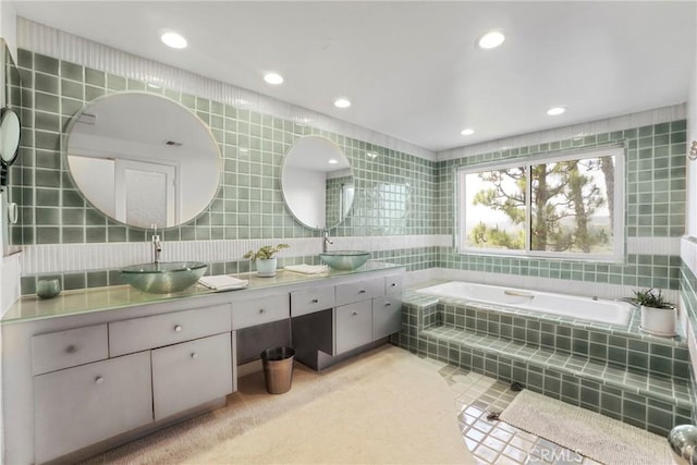 2311 Roscomare Rd Unit 16, Los Angeles, CA 90077 - bathroom featuring tile walls, double vanity, a garden tub, recessed lighting, and tile patterned floors
