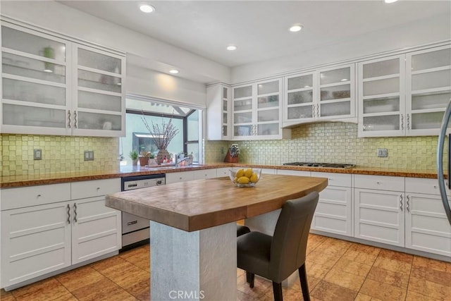 2311 Roscomare Rd Unit 16, Los Angeles, CA 90077 - kitchen featuring dishwasher, wooden counters, a breakfast bar area, stainless steel gas cooktop, and glass insert cabinets