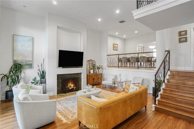 2311 Roscomare Rd Unit 16, Los Angeles, CA 90077 - living area featuring wood finished floors, a lit fireplace, stairs, and recessed lighting