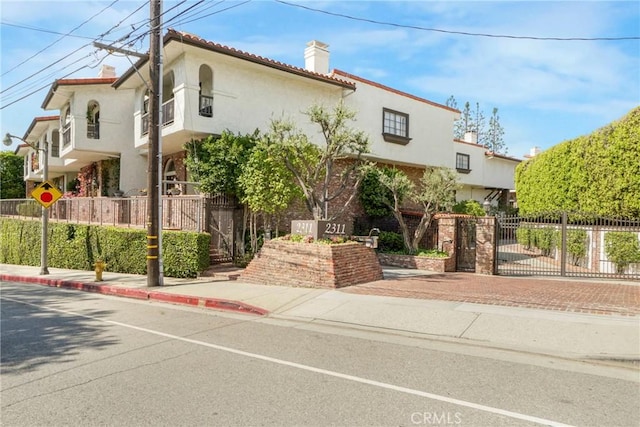 2311 Roscomare Rd Unit 16, Los Angeles, CA 90077 - mediterranean / spanish home with stucco siding, a gate, and a chimney
