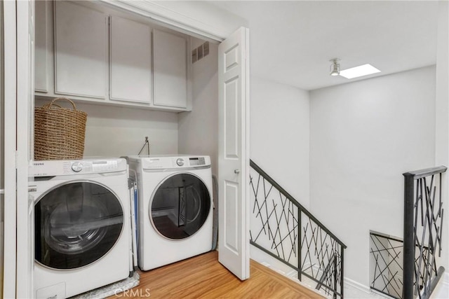 2311 Roscomare Rd Unit 16, Los Angeles, CA 90077 - washroom featuring cabinet space, washing machine and dryer, and light wood-type flooring