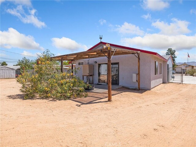 14060 Osage Rd, Apple Valley, CA 92307 - rear view of house with a gate, stucco siding, and fence