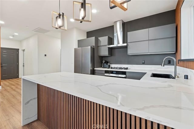 6296 Diamond Ave, Paradise, CA 95969 - kitchen featuring freestanding refrigerator, wall chimney exhaust hood, a sink, gray cabinetry, and light wood-style floors