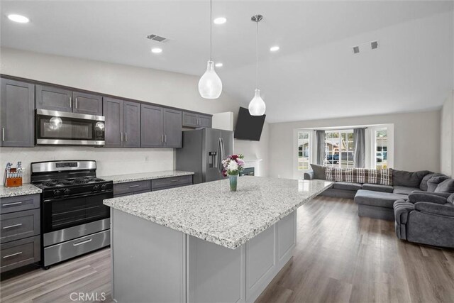 19018 Tule Way, Lake Elsinore, CA 92530 - kitchen featuring stainless steel appliances, vaulted ceiling, open floor plan, a kitchen island, and wood finished floors