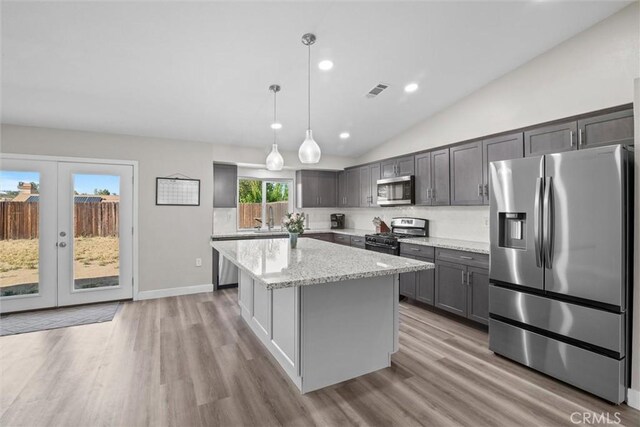 19018 Tule Way, Lake Elsinore, CA 92530 - kitchen with appliances with stainless steel finishes, a kitchen island, light stone countertops, light wood-type flooring, and decorative light fixtures