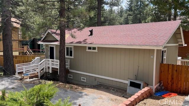 33421 Wild Rose Dr, Green Valley Lake, CA 92341 - rear view of property featuring fence and a shingled roof