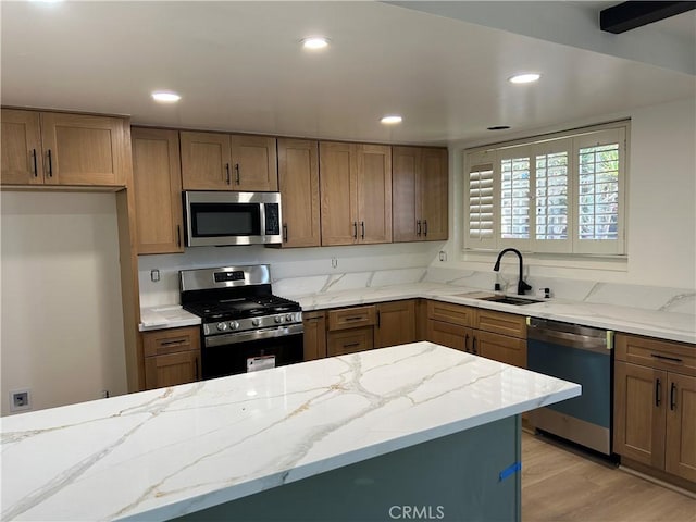 990 244th St, Harbor City, CA 90710 - kitchen with appliances with stainless steel finishes, a sink, light stone countertops, brown cabinets, and light wood-style flooring