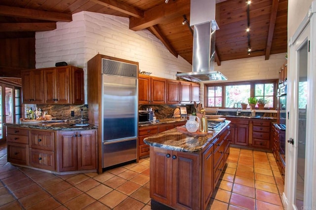 11105 Berry Rd, Valley Center, CA 92082 - kitchen with a wooden ceiling with exposed beams, stainless steel appliances, island exhaust hood, tasteful backsplash, and brown cabinetry