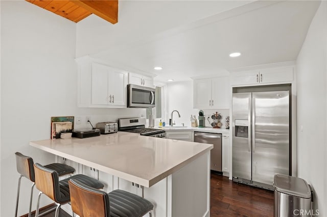 1803 Nob Hill Dr, Running Springs, CA 92382 - kitchen featuring stainless steel appliances, a sink, dark wood-style floors, a peninsula, and white cabinetry