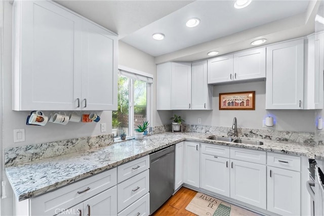1121 E 1st St, Tustin, CA 92780 - kitchen with stainless steel appliances, a sink, white cabinets, light wood-type flooring, and recessed lighting