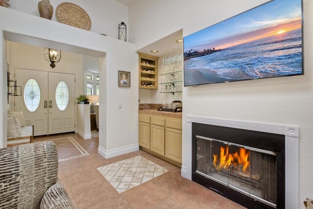3749 Sarah Ann Dr, Fallbrook, CA 92028 - foyer with light tile patterned floors, baseboards, a warm lit fireplace, and a high ceiling