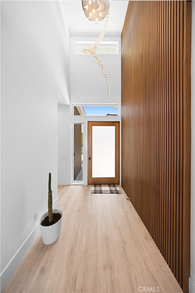 1270 W Chase Dr, Corona, CA 92882 - corridor featuring a chandelier, wood finished floors, a towering ceiling, and baseboards