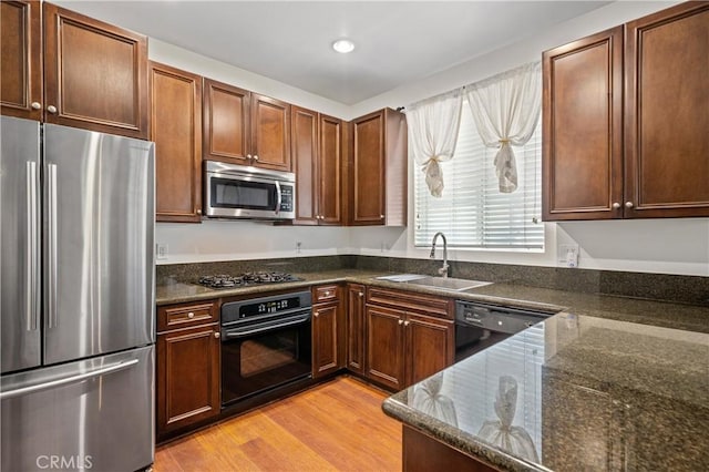 30505 Canyon Hills Rd Unit 1205, Lake Elsinore, CA 92532 - kitchen with black appliances, a sink, dark stone countertops, light wood-style floors, and recessed lighting