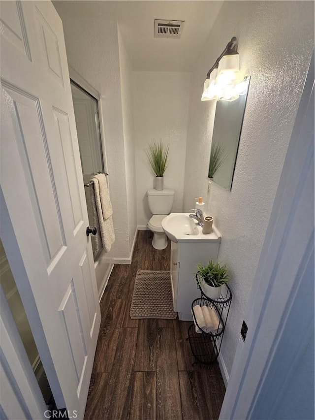 355 Woodlark St, Lancaster, CA 93535 - full bath with wood finished floors, vanity, a textured wall, baseboards, and toilet
