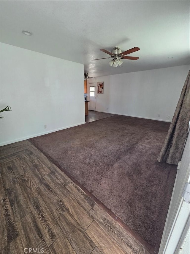 355 Woodlark St, Lancaster, CA 93535 - unfurnished living room featuring ceiling fan, baseboards, dark wood-style floors, and dark colored carpet