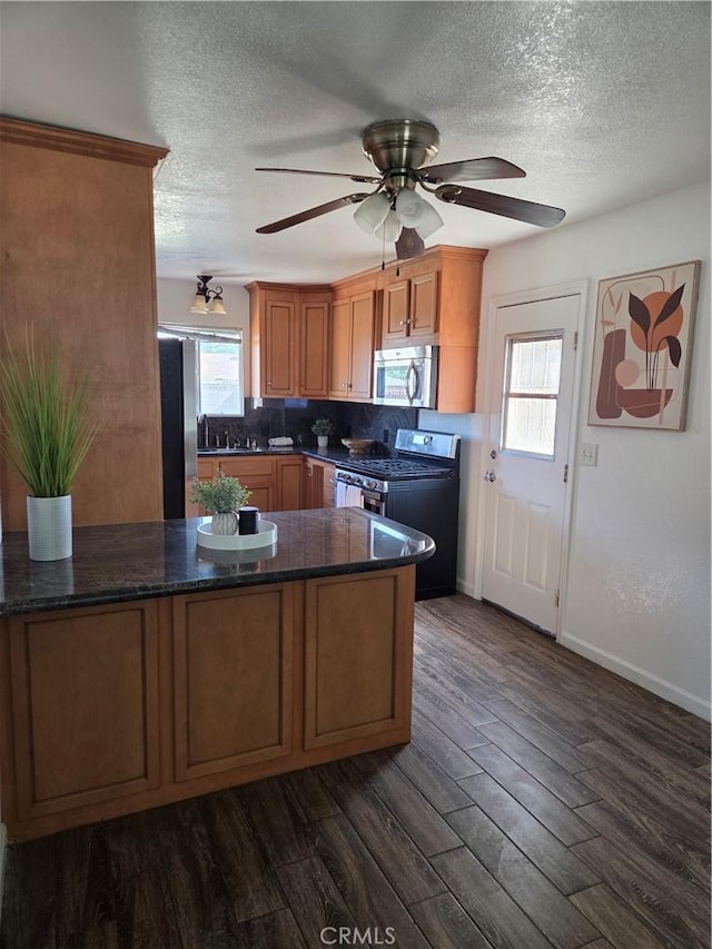 355 Woodlark St, Lancaster, CA 93535 - kitchen with appliances with stainless steel finishes, ceiling fan, a textured ceiling, dark wood-type flooring, and a peninsula