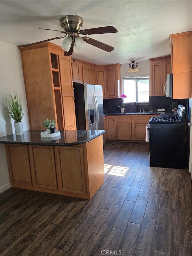 355 Woodlark St, Lancaster, CA 93535 - kitchen with stainless steel appliances, dark wood finished floors, decorative backsplash, and brown cabinetry