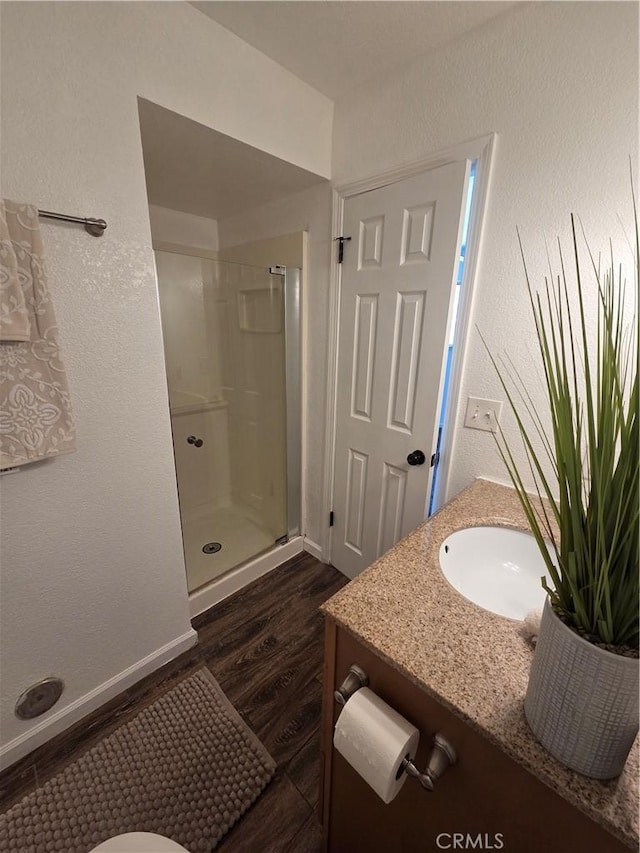 355 Woodlark St, Lancaster, CA 93535 - bathroom featuring wood finished floors, a stall shower, vanity, and a textured wall