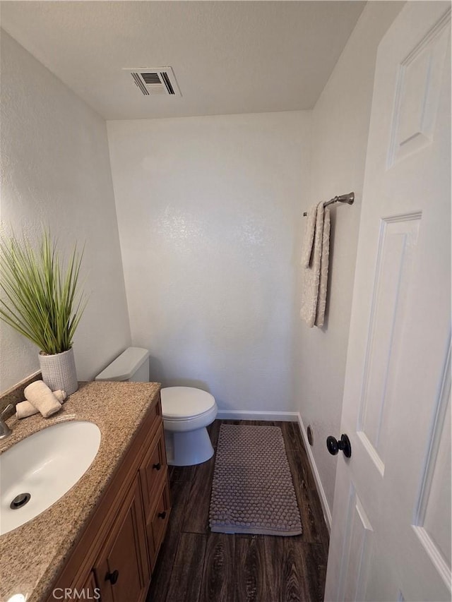 355 Woodlark St, Lancaster, CA 93535 - bathroom featuring wood finished floors, toilet, vanity, and baseboards