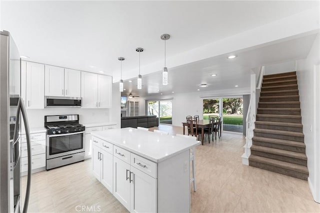 13421 Epping Way, Tustin, CA 92780 - kitchen featuring appliances with stainless steel finishes, white cabinetry, light countertops, recessed lighting, and a kitchen island