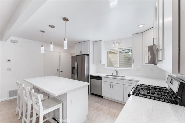 13421 Epping Way, Tustin, CA 92780 - kitchen with appliances with stainless steel finishes, a sink, a kitchen island, a kitchen breakfast bar, and light countertops