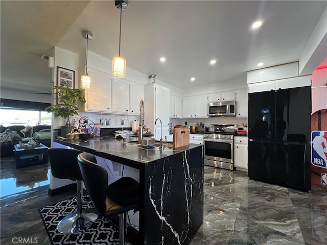 15245 Apache Rd, Apple Valley, CA 92307 - kitchen with appliances with stainless steel finishes, dark countertops, a peninsula, hanging light fixtures, and recessed lighting