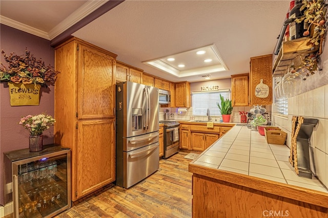 43156 41st St W, Lancaster, CA 93536 - kitchen with appliances with stainless steel finishes, tile countertops, crown molding, light wood finished floors, and a sink