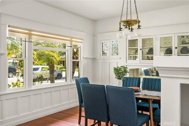 528 E Palmyra Ave, Orange, CA 92866 - dining space featuring a decorative wall, dark wood-type flooring, a chandelier, and wainscoting