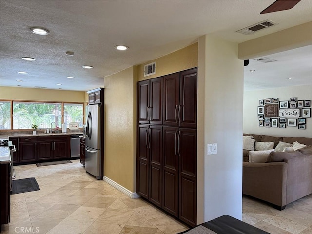 28726 Macklin Ave, Canyon Country, CA 91387 - kitchen featuring appliances with stainless steel finishes, a sink, open floor plan, dark brown cabinets, and recessed lighting