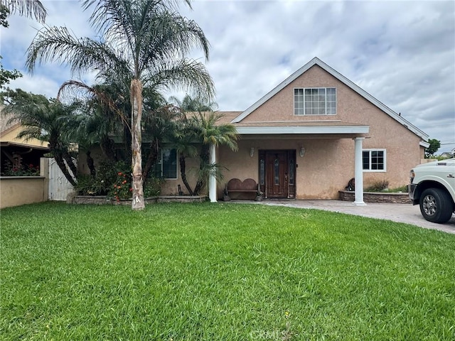 view of front of house featuring stucco siding and a front lawn