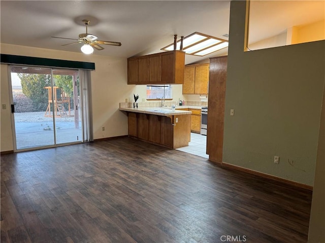 14686 Cool Glen Dr, Helendale, CA 92342 - kitchen with lofted ceiling, a peninsula, light countertops, ceiling fan, and baseboards