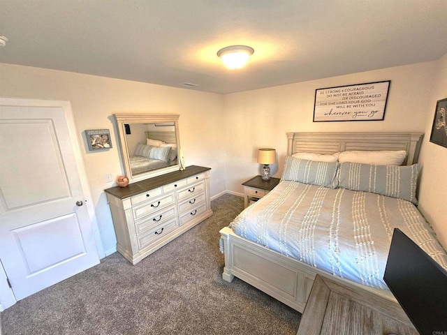bedroom with dark carpet and baseboards