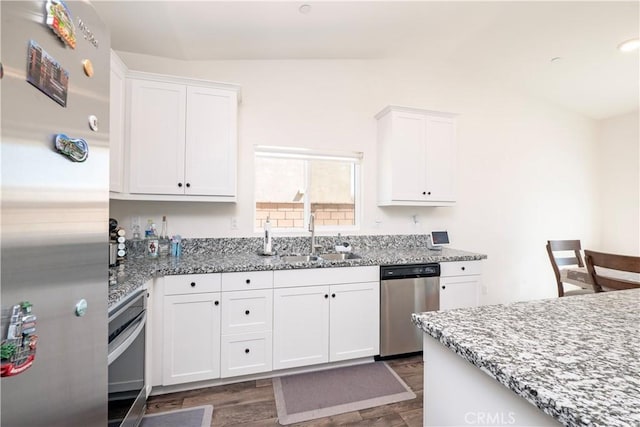 15667 San Diego Ln, Victorville, CA 92394 - kitchen featuring appliances with stainless steel finishes, a sink, dark wood-type flooring, white cabinetry, and lofted ceiling