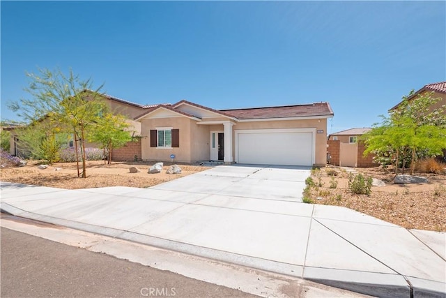 15667 San Diego Ln, Victorville, CA 92394 - ranch-style home featuring stucco siding, an attached garage, concrete driveway, and solar panels