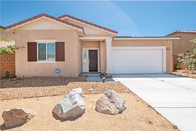 15667 San Diego Ln, Victorville, CA 92394 - view of front of house featuring driveway, an attached garage, and stucco siding