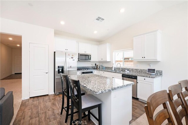 15667 San Diego Ln, Victorville, CA 92394 - kitchen with appliances with stainless steel finishes, a center island, dark wood-style floors, white cabinetry, and a sink