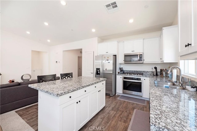 15667 San Diego Ln, Victorville, CA 92394 - kitchen with stainless steel appliances, a sink, a kitchen island, light stone countertops, and white cabinetry