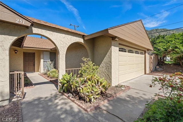 251 Mountain Crest Rd, Duarte, CA 91010 - property entrance featuring stucco siding, a garage, and driveway