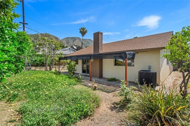 251 Mountain Crest Rd, Duarte, CA 91010 - rear view of property with central AC, stucco siding, a chimney, a mountain view, and roof with shingles