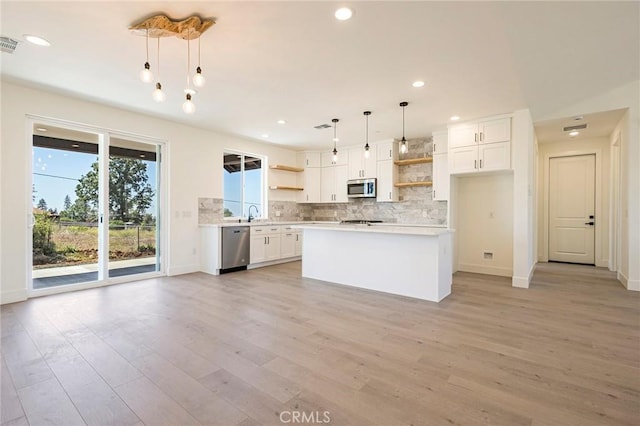 1890 Arrowhead Dr, Paradise, CA 95969 - kitchen with open shelves, stainless steel appliances, tasteful backsplash, light countertops, and white cabinetry