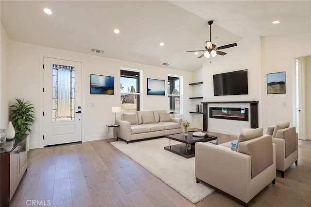 1890 Arrowhead Dr, Paradise, CA 95969 - living area featuring vaulted ceiling, wood finished floors, ceiling fan, a glass covered fireplace, and recessed lighting