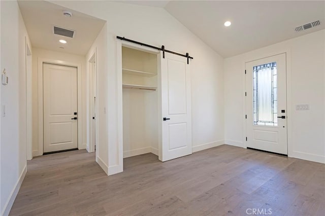 1890 Arrowhead Dr, Paradise, CA 95969 - foyer featuring a barn door, wood finished floors, vaulted ceiling, baseboards, and recessed lighting